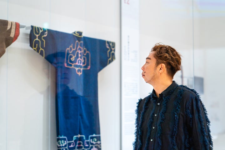 国立アイヌ民族博物館で伝統衣服の展示に見入るÜSAさん。「洋服でもなんでも、パッと手に入る便利な時代。けれども、思いを込めて、時間をかけてつくったものに出会うと、心を動かされます。改めて、一つ一つのものに愛をこめて使っていきたいな、という気持ちになりました」