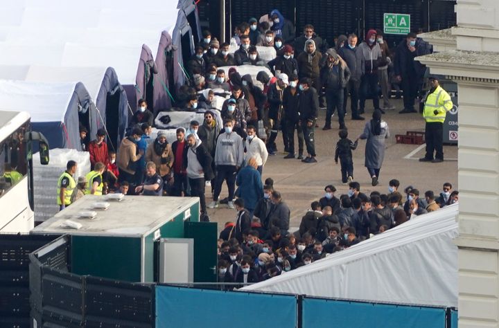 People thought to be migrants wait to be processed at the Border Force compound in Dover, Kent,