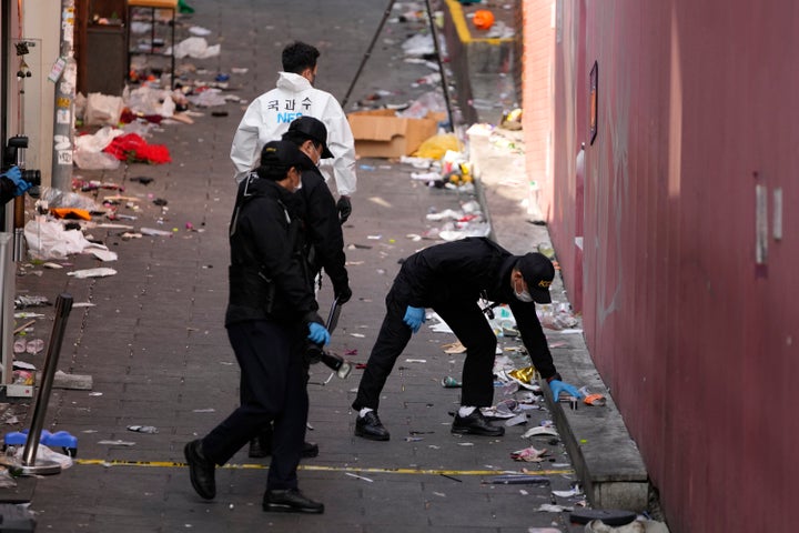 South Korean investigators inspect the scene of a deadly accident following Saturday night's Halloween festivities in Seoul, South Korea, on Oct. 31, 2022. 