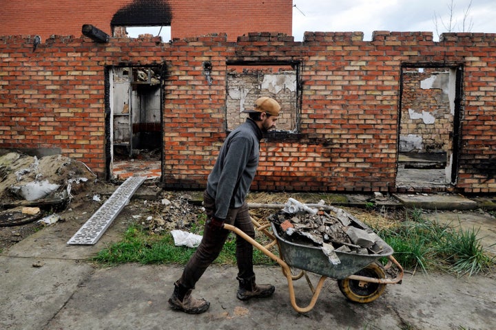 A volunteer clears the rubble of a destroyed house as a result of shelling in the village of Moshchun, Kyiv region, on Oct. 29, 2022, amid the Russian invasion of Ukraine.