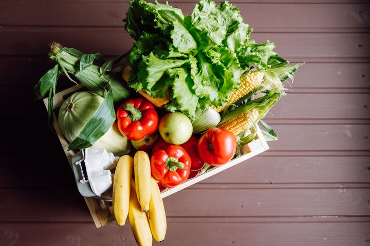 High angle view wooden box filled with fresh vegetables, fruits, eggs