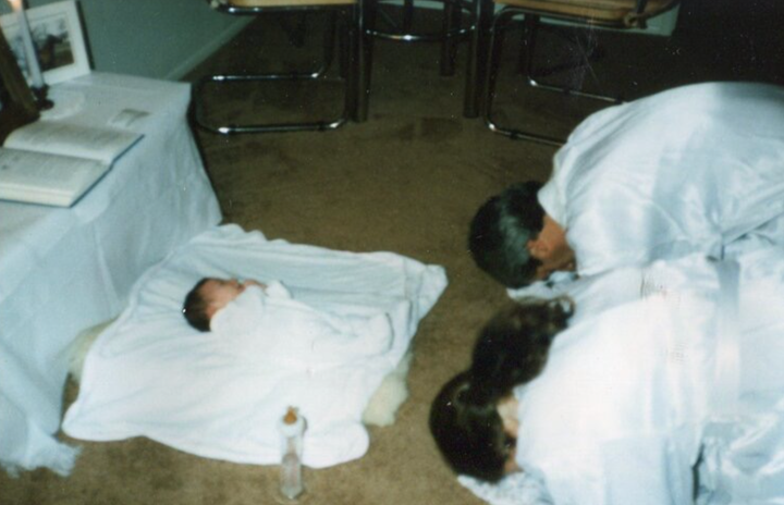 The author’s parents holding an “Eight Day Ceremony” for her younger sister, during which she was dedicated to God.