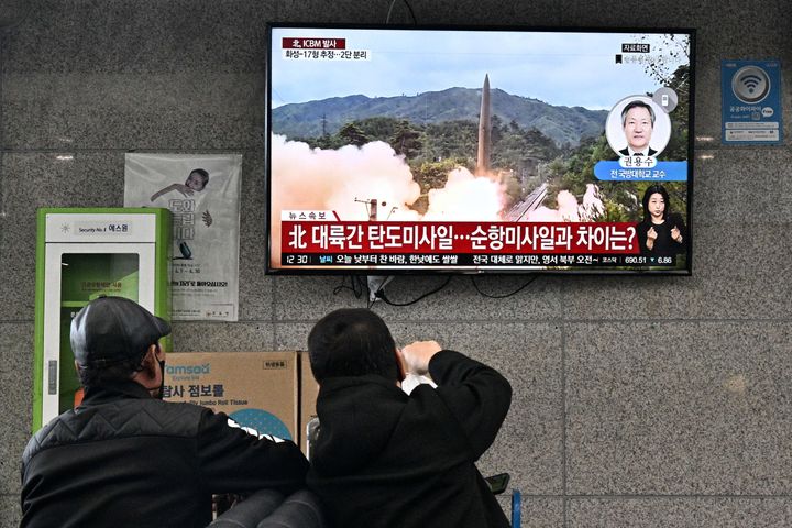 Visitors watch a news broadcast showing file footage of a North Korean missile test at the ferry terminal of South Korea's eastern island of Ulleungdo, in the East Sea, also known as the Sea of Japan, on November 3, 2022. (Photo by Anthony WALLACE / AFP) (Photo by ANTHONY WALLACE/AFP via Getty Images)