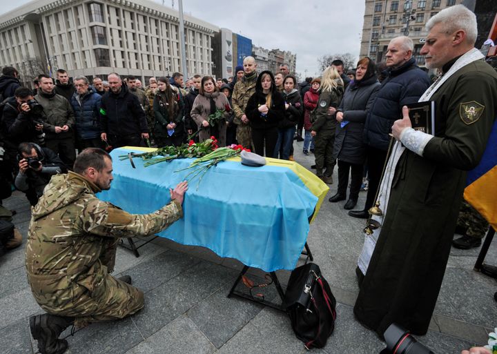 A Ukrainian soldier pays respect to the Ukrainian serviceman Volodymyr Karas during the funeral ceremony in Independence Square in central Kyiv. Vladimir Karas died on March 3, 2022, in the village of Motyzhyn in a battle with Russian invaders. 