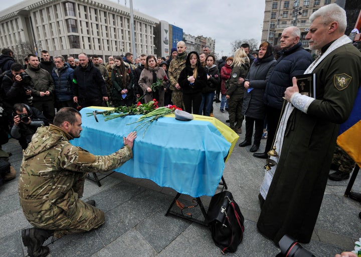 A Ukrainian soldier pays respect to the Ukrainian serviceman Volodymyr Karas during the funeral ceremony in Independence Square in central Kyiv. Vladimir Karas died on March 3, 2022, in the village of Motyzhyn in a battle with Russian invaders.