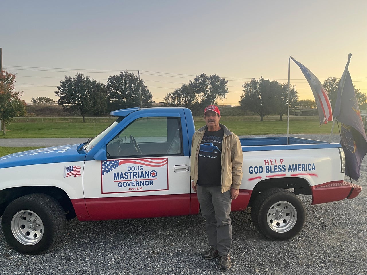 Carl from Hershey, Pennsylvania, stands with his truck, which is covered in decals supporting Mastriano, in Manheim on Oct. 21.