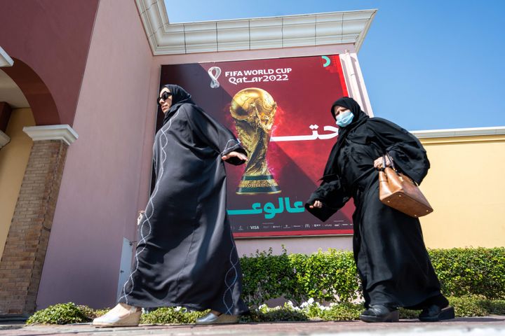 Γυναίκες περνούν δίπλα από ένα πανό του Παγκοσμίου Κυπέλλου FIFA στη Ντόχα στις 3 Νοεμβρίου 2022. 