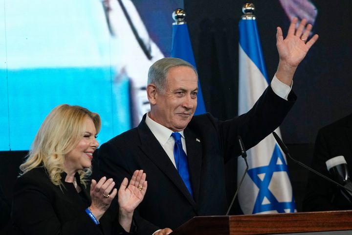 Benjamin Netanyahu, former Israeli Prime Minister and the head of Likud party, accompanied by his wife Sara waves to his supporters after first exit poll results for the Israeli Parliamentary election at his party's headquarters in Jerusalem, Wednesday, Nov. 2, 2022. (AP Photo/Tsafrir Abayov)