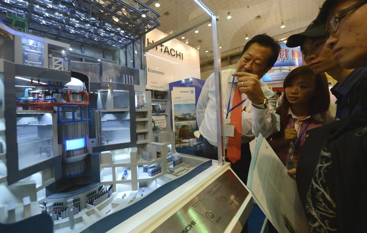 Students look at a model of a nuclear power plant jointly designed by Hitachi and General Electric on display at an international nuclear power exhibition being held in Hanoi, Vietnam, in October 2012.