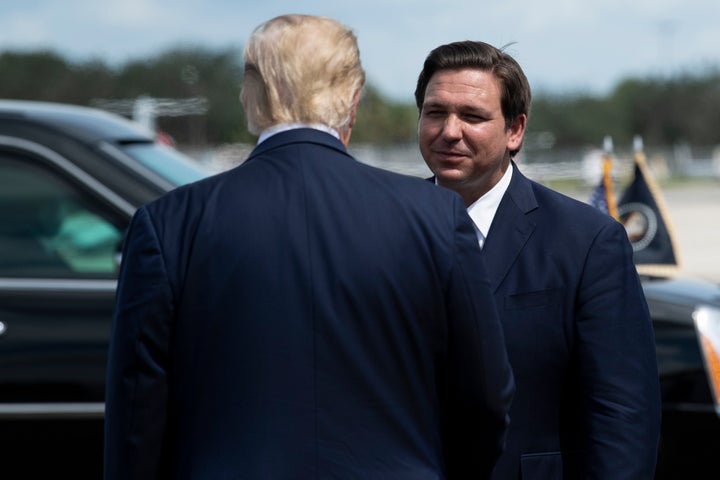 Then-President Donald Trump is greeted by Florida Gov. Ron DeSantis on Oct. 16, 2020, in Fort Myers, Florida.
