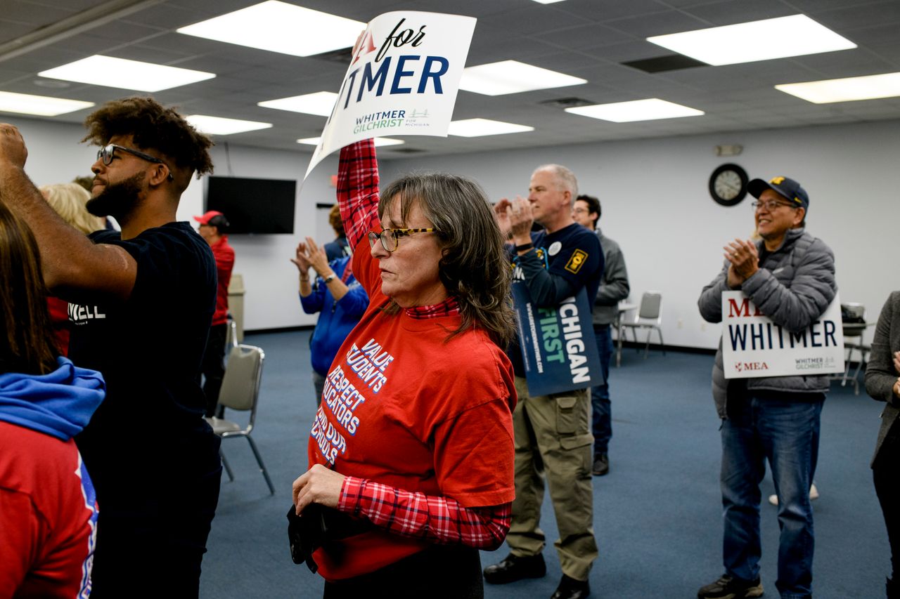 Liza Parkinson, an organizer with the Michigan Education Association, holds a sign in support of Whitmer during a campaign event at the UAW Local 3000 offices on Oct. 26.