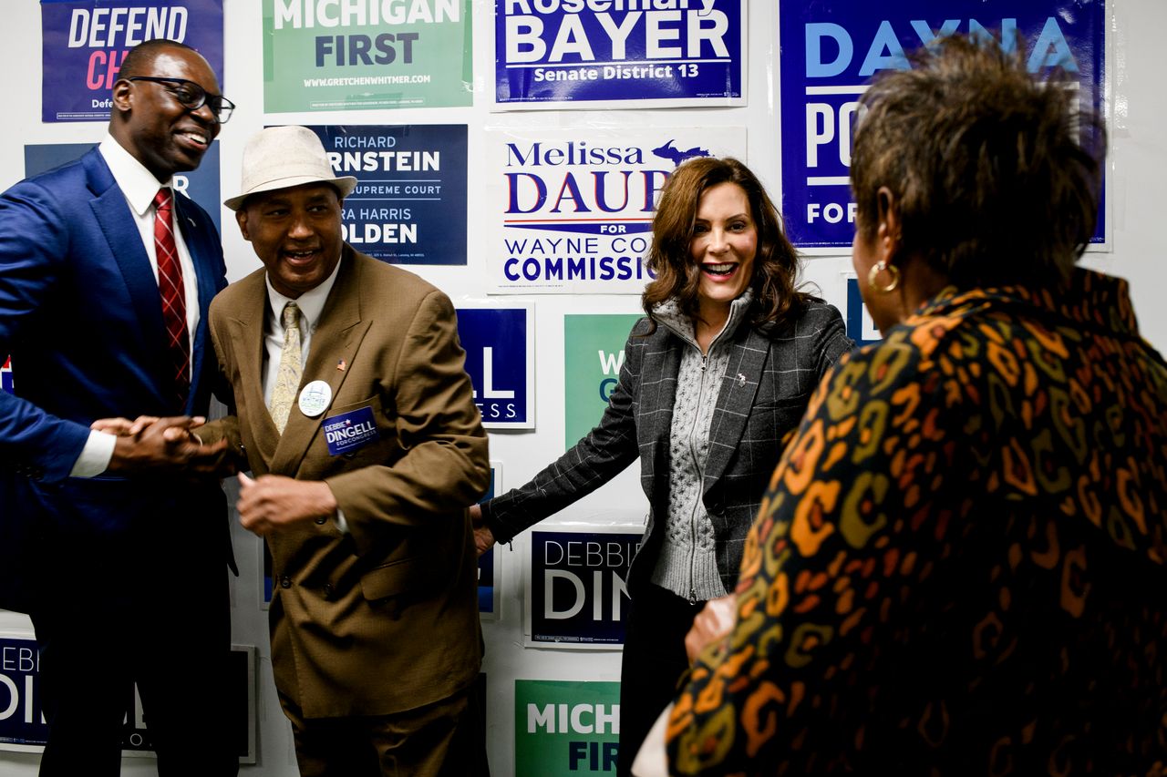 Whitmer greets Rodrick Casey, left, and Pecola Lewis, right, both of Ypsilanti Township, for a photo opportunity following a campaign event at a local campaign office in Canton on Oct. 26.
