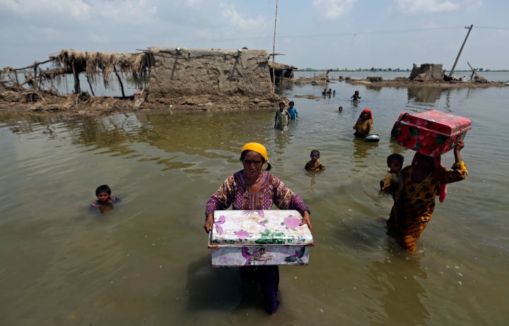 Women carry belongings salvaged from their flooded home after monsoon rains, in the Qambar Shahdadkot district of Sindh Province, of Pakistan, Sept. 6, 2022. Earth’s warming weather and rising seas are getting worse and doing so faster than before, the World Meteorological Organization warned Sunday, Nov. 6, 2022, in a somber note as world leaders started gathering for international climate negotiations in the Egyptian resort of Sharm el-Sheikh. (AP Photo/Fareed Khan, File)