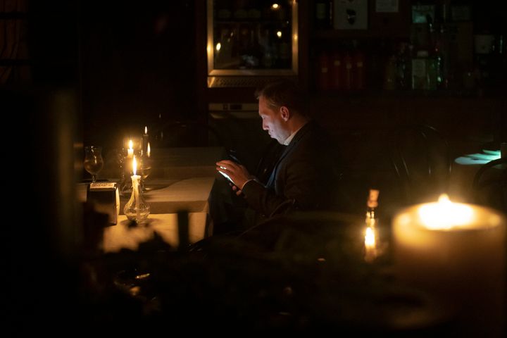 A man sits in a caffe during a blackout in Kyiv, Ukraine, Friday, Nov. 4, 2022.
