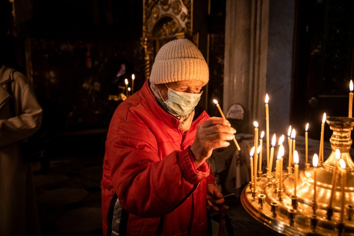 Worshippers pray and light candles in St. Volodymyr's Cathedral, the Ukrainian Orthodox Church of the Kyiv Patriarchate, on Sunday November 06, 2022 in Kyiv, Ukraine. Electricity and heating outages across Ukraine caused by missile and drone strikes to energy infrastructure have added urgency preparations for winter.