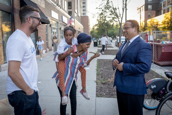 Democratic Rep. Ilhan Omar of Minnesota (center) talks to Ellison on the day of primary voting in August. Omar nearly lost to a challenger who criticized her support for radical policing policies.