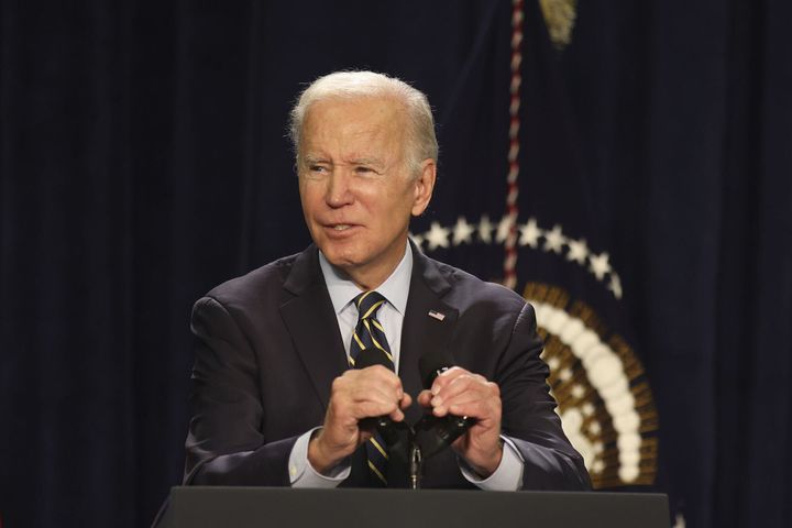 President Joe Biden adjust his microphones while speaking at Jones Elementary School on Nov. 5, 2022, in Joliet, Illinois.