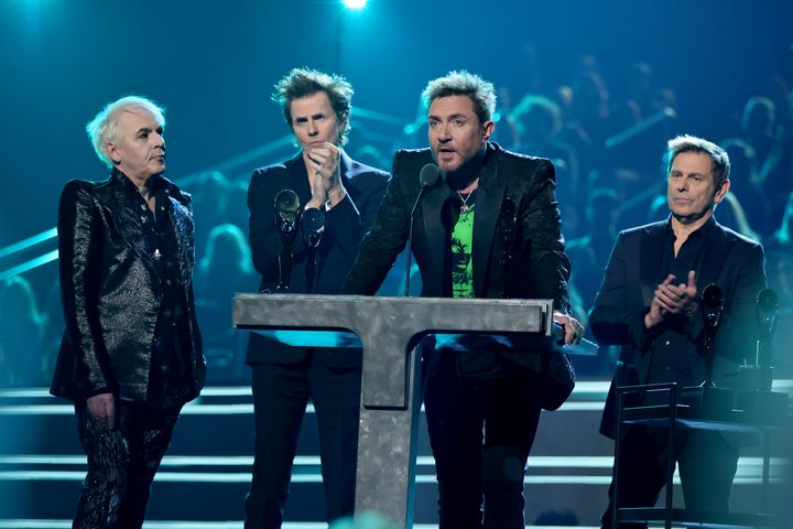 Duran Duran lead singer Simon Le Bon (at the podium) reads Taylor's letter at the Microsoft Theater in Los Angeles.