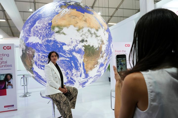 A woman poses for photos at the COP27 U.N. Climate Summit, on Nov. 7, 2022, in Sharm el-Sheikh, Egypt. 