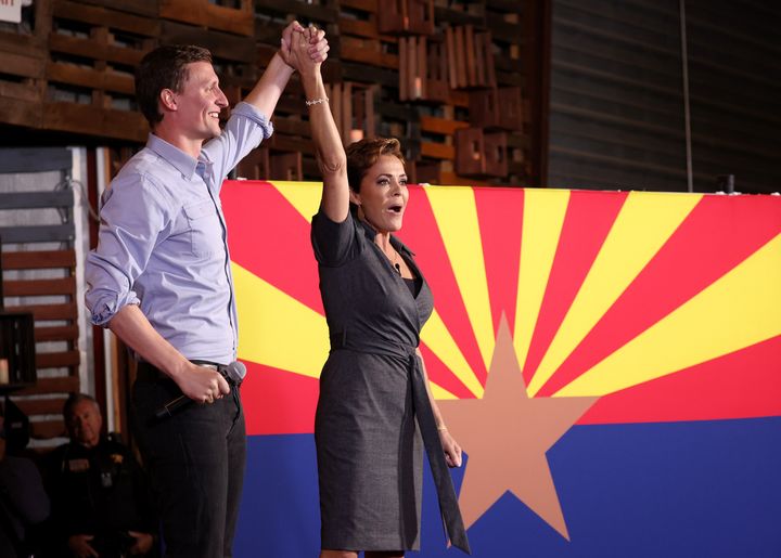 Arizona Republican gubernatorial candidate Kari Lake (right) and Arizona U.S. Senate candidate Blake Masters raise their arms at a campaign rally on Nov. 5 in Queen Creek, Arizona. 