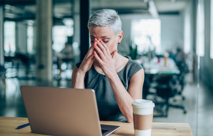 Shot of a stressed businesswoman with headache in the office