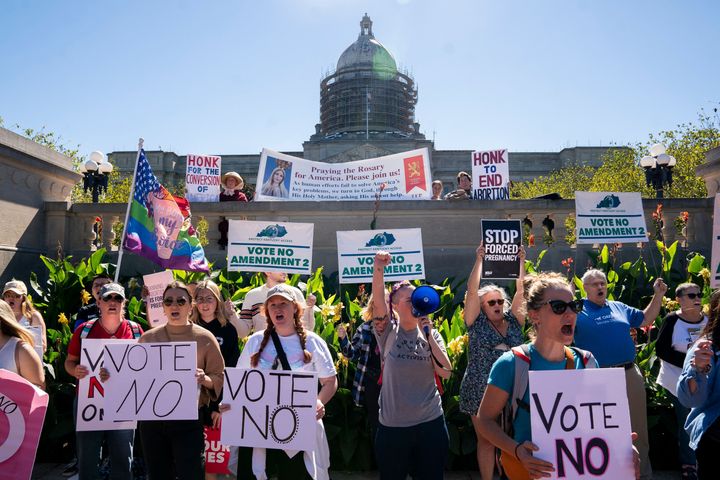 Counterprotesters hold signs in front of a rally encouraging voters to vote yes on Amendment 2, which would add a permanent abortion ban to Kentucky's state constitution, on the steps of the state Capitol in Frankfort, Oct. 1, 2022.