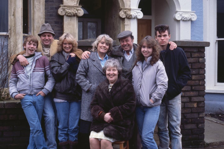 Original EastEnders cast members, including Gillian Taylforth and Bill Treacher, pose on the show's set