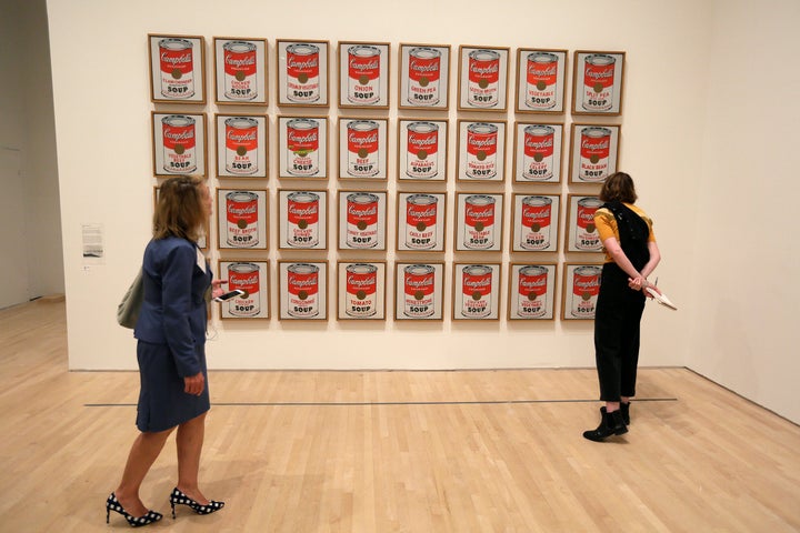 Climate protesters in Australia scrawled graffiti and glued themselves to an Andy Warhol artwork depicting Campbell's soup cans but didn't appear to damage the piece because it's encased in glass.