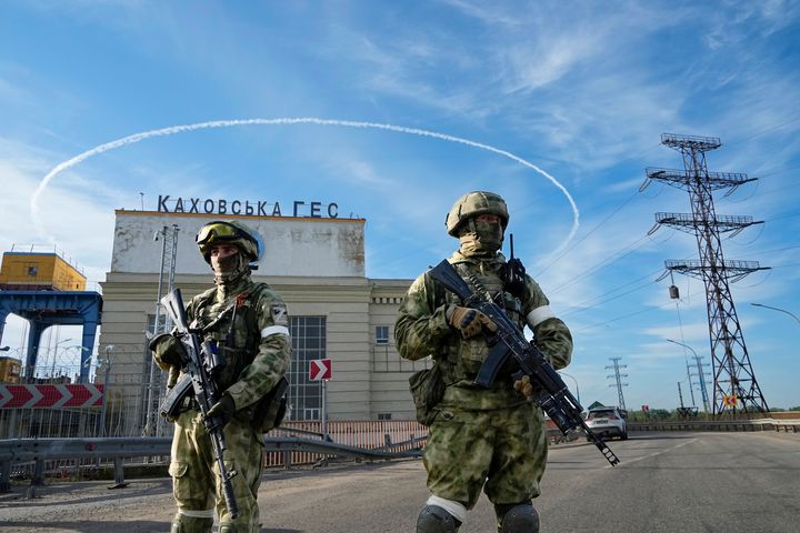 Russian troops guard an entrance of the Kakhovka Hydroelectric Station in southern Ukraine. On Wednesday, Russia announced its planned retreat from Kherson, a regional capital.