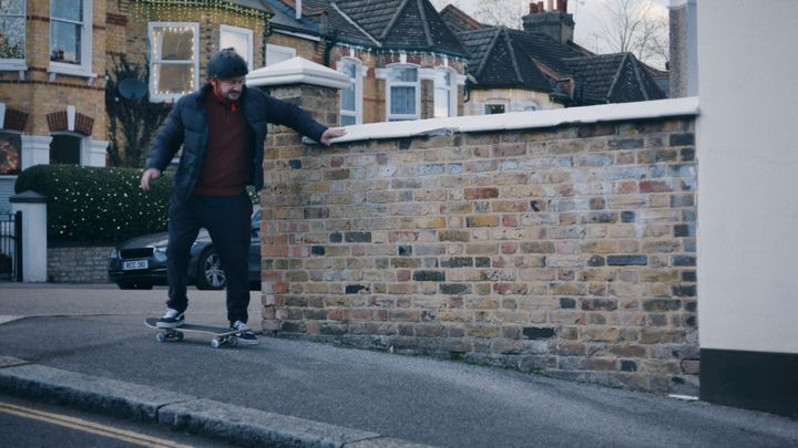 A still from the John Lewis ad where a foster carer is trying to master the art of skateboarding so he can bond with a teenage girl.