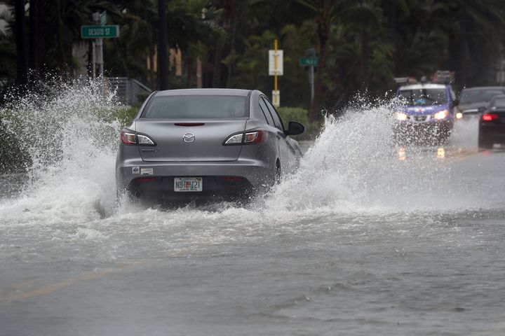A car tries to navigate a flooded road in Hollywood Beach on Wednesday.