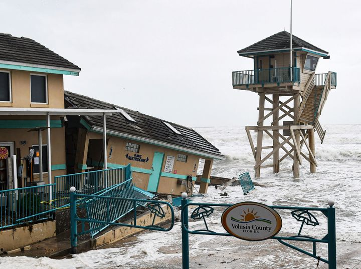 Waves crash near a damaged building and a lifeguard tower in Daytona Beach Shores in Florida Wednesday.