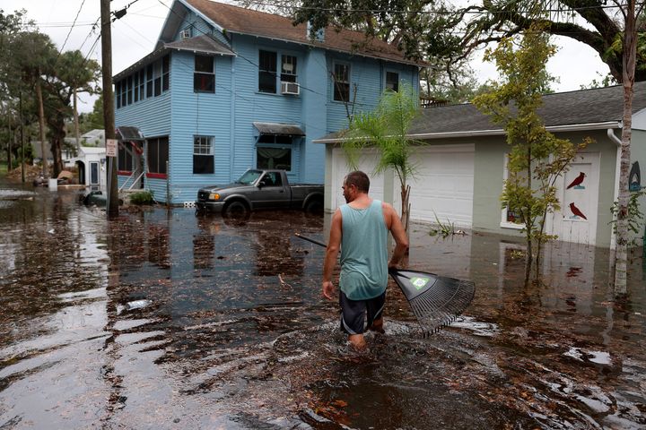 A man walks through flood water that surrounds his home in Daytona Beach on Thursday.