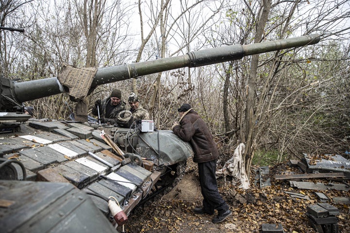 Ukrainian soldiers repair a damaged tank as armed forces continue toward the Kherson front in Ukraine on Nov. 9, 2022.