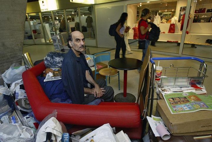 Mehran Karimi Nasseri sits amid his belongings in 2004 at Charles de Gaulle Airport, where he initially set up a living space because he lacked residency papers to leave.