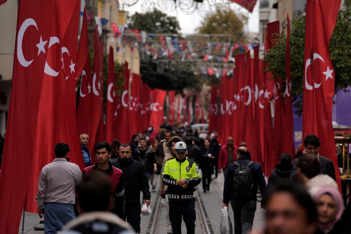 Ένας αστυνομικός ανάμεσα σε πλήθος κόσμου που περπατά στη λεωφόρο Ιστικλάλ της Κωνσταντινούπολης, Δευτέρα, 14 Νοεμβρίου 2022