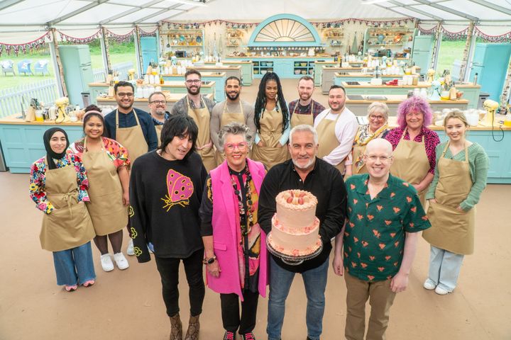 From left to right, host Noel Fielding, judges Prue Leith and Paul Hollywood and host Matt Lucas stand in front of the bakers of this season of "The Great British Bake Off."