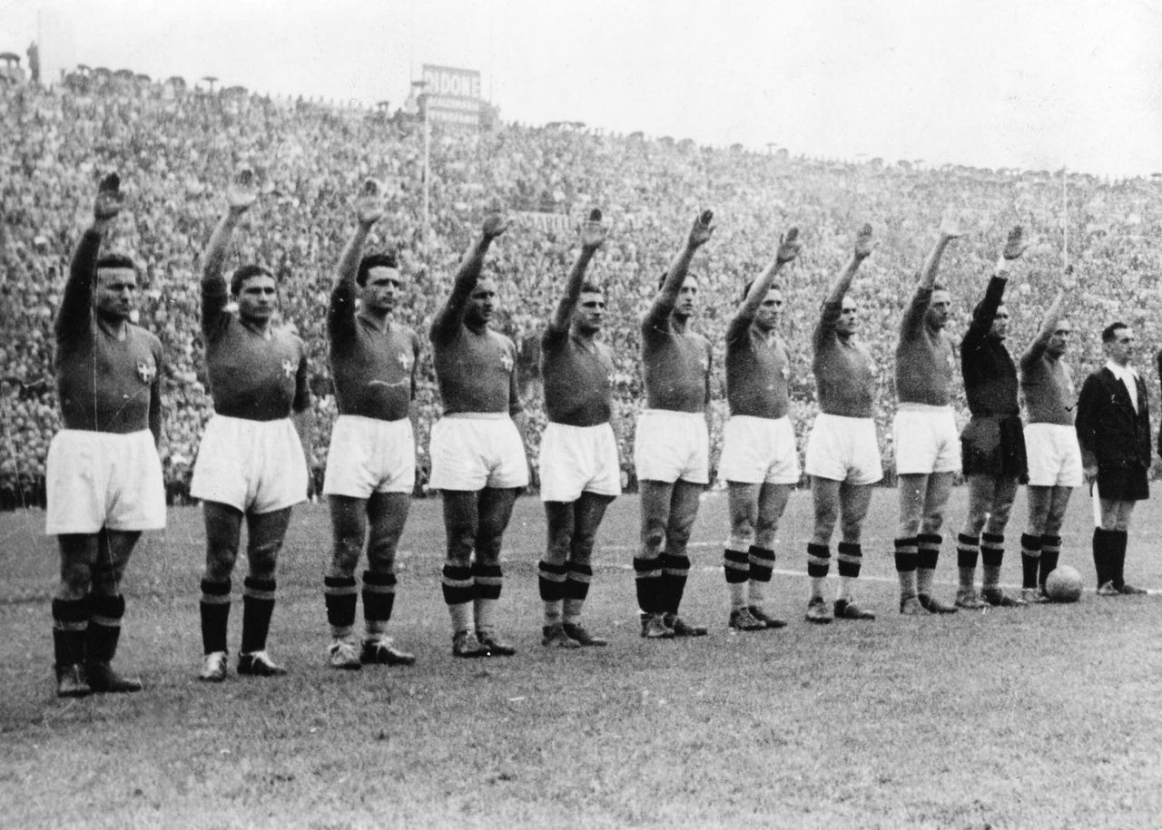 Η εθνική ομάδα της Ιταλίας χαιρετάει ναζιστικά πριν την έναρξη του τελικού στο Στάδιο Κολόμπ στο Παρίσι με αντίπαλο την Ουγγαρία στις 19 Ιουνίου 1938. Η Ιταλία θα κατακτήσει το πρώτο από τα δύο Ζιλ Ριμέ τρόπαια νικώντας τους Μαγυάρους με 4-2.
