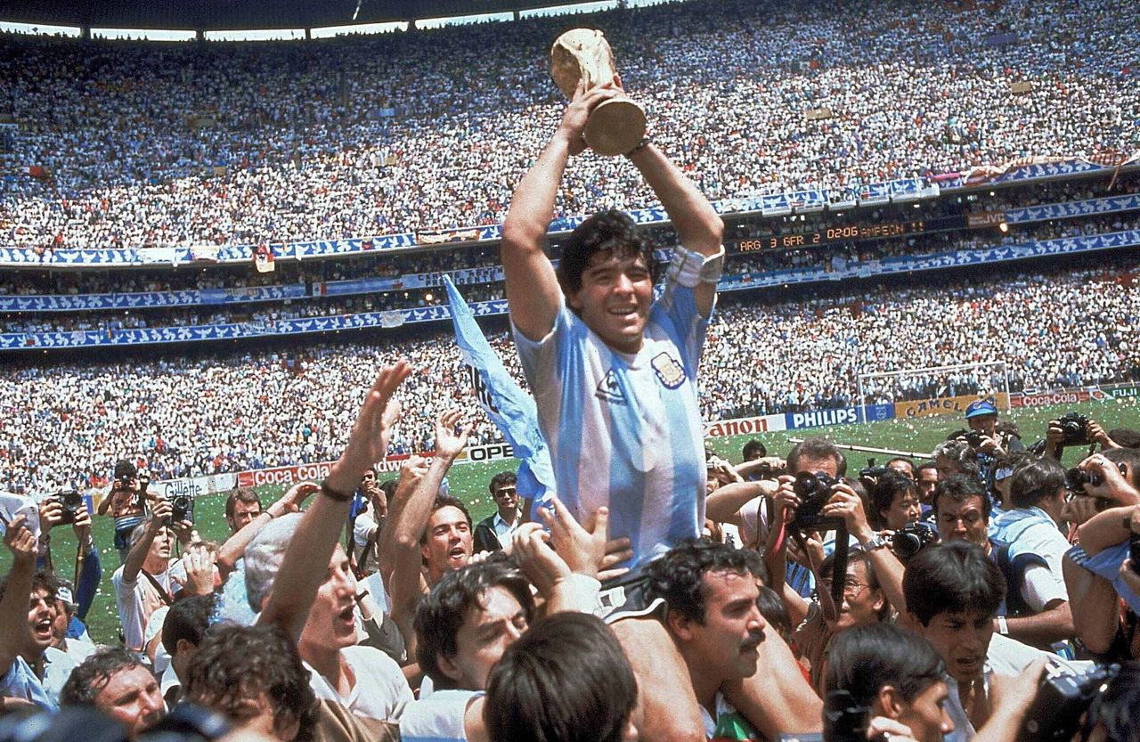 Μέξικο Σίτι - Στάδιο Αζτέκα, 29 Ιουνίου 1986. Η Αργεντινή έχει μόλις κερδίσει την Δυτική Γερμανία με 3-2 στον τελικό. Ο Ντιέγκο Μαραντόνα στους ώμους των φιλάθλων της Αργεντινής κάνει το γύρο του θριάμβου με το παγκόσμιο κύπελλο στα χέρια. 