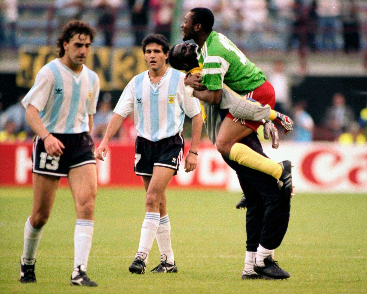 Απογοητευμένοι οι παίκτες της Αργεντινής Νέστορ Λορέντζο (με το νούμερο 13) και Χόρχε Μπουρουσάγα, αποχωρούν από τον αγωνιστικό χώρο του Τζουζέπε Μεάτσα στο Μιλάνο, μετά την ήττα με 1-0 από το Καμερούν στο εναρκτήριο παιχνίδι του Italia '90, στις 8 Ιουνίου.