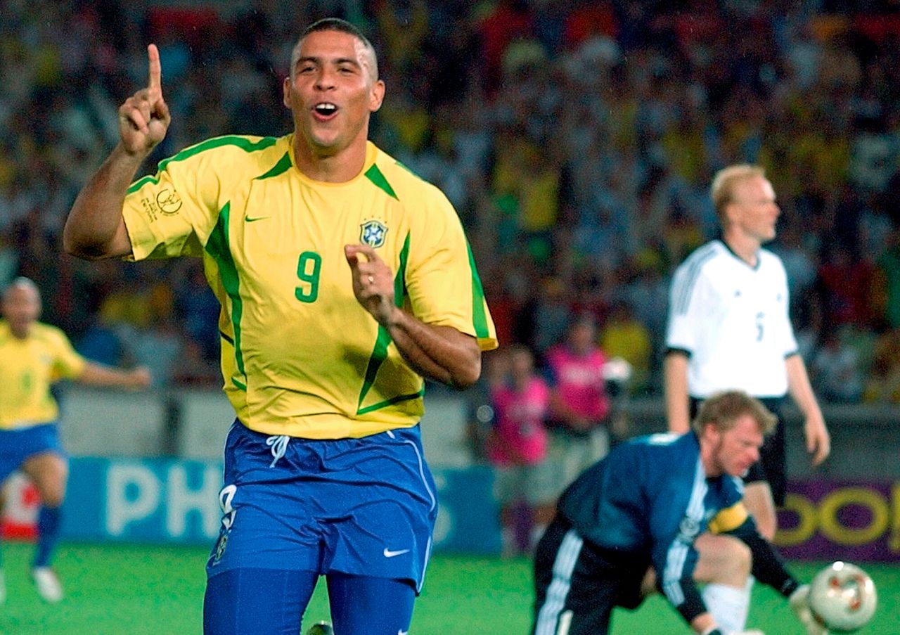 Ο Ρονάλντο της Βραζιλίας πανηγυρίζει το δεύτερο γκολ στον τελικό με την Γερμανία στο Στάδιο Γιοκοχάμα, στη Γιοκοχάμα της Ιαπωνίας στις 30 Ιουνίου 2002. Η Βραζιλία κέρδισε με 2-0 με τον Ρονάλντο να σκοράρει και τα δύο γκολ, κατακτώντας για τέταρτη φορά το Παγκόσμιο Κύπελλο.<br>Πίσω του διακρίνονται ο τερματοφύλακας Όλιβερ Καν και ο κεντρικός αμυντικός Κάρστεν Ράμελοβ.