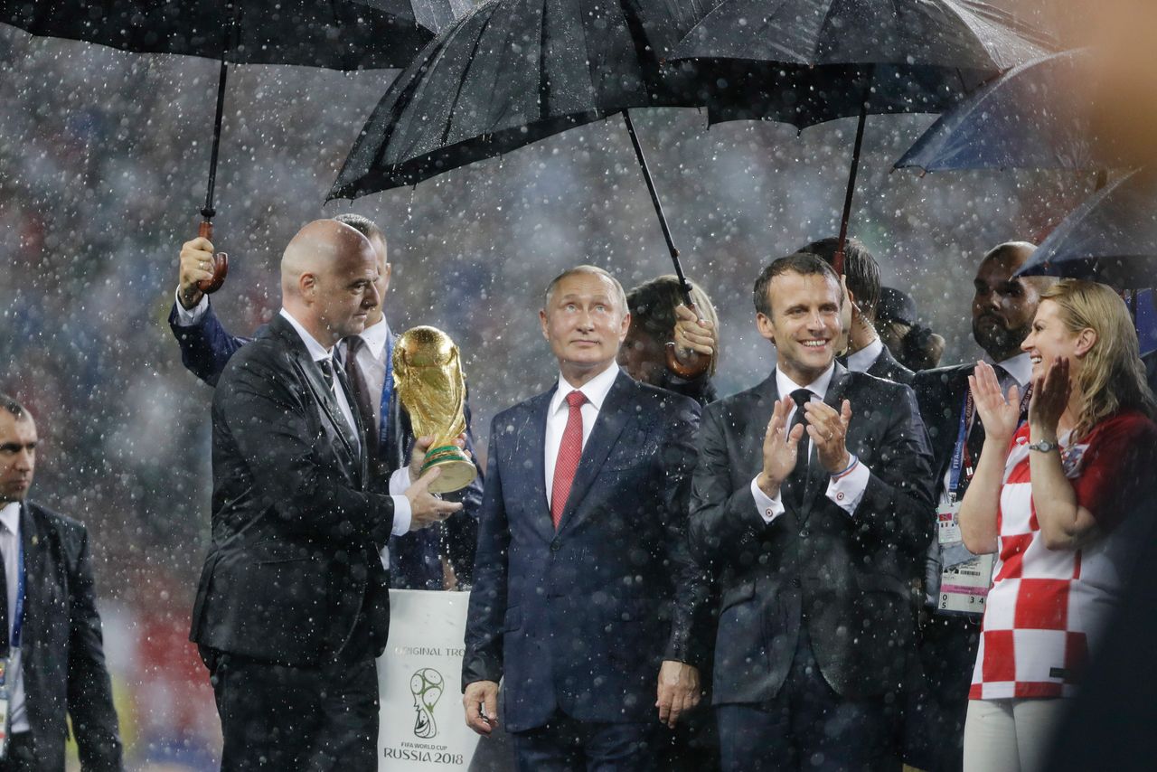 Από αριστερά προς τα δεξιά: Ο πρόεδρος της FIFA Τζιάνι Ινφαντίνο, ο πρόεδρος της Ρωσίας Βλαντιμίρ Πούτιν, ο πρόεδρος της Γαλλίας Εμανουέλ Μακρόν και η πρόεδρος της Κροατίας Κολίντα Γκράμπαρ-Κιτάροβιτς, κατά τη διάρκεια της τελετής απονομής, κάτω από καταρρακτώδη βροχή, μετά τον τελικό του Παγκοσμίου Κυπέλλου, μεταξύ Γαλλίας και Κροατίας το 2018 στο Στάδιο Λουζνίκι της Μόσχας, την Κυριακή 15 Ιουλίου 2018.