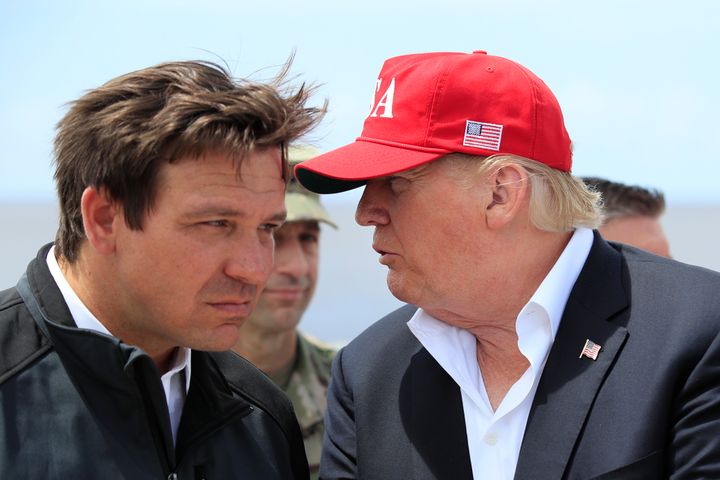 President Donald Trump talks to Florida Gov. Ron DeSantis, left, during a visit to Lake Okeechobee and Herbert Hoover Dike at Canal Point, Florida, March 29, 2019.