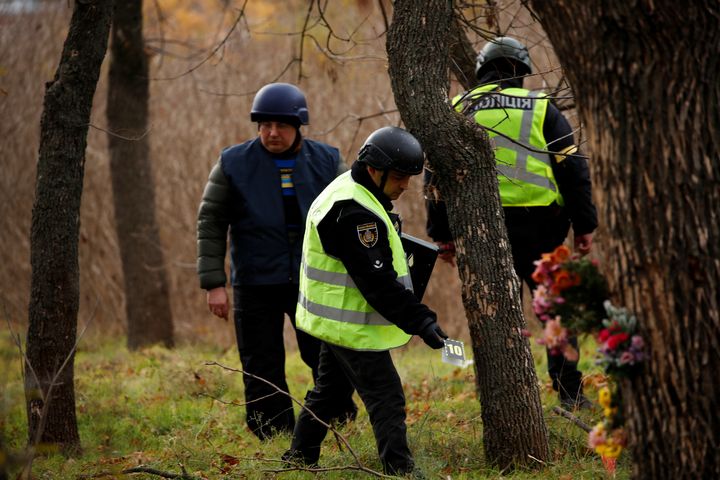 Ιατροδικαστές της ουκρανικής αστυνομίας αναζητούν στοιχεία σε ένα πάρκο όπου έγιναν μάχες μεταξύ ουκρανικών και ρωσικών δυνάμεων στην αρχή του πολέμου, στη Χερσώνα της Ουκρανίας, 16 Νοεμβρίου 2022.