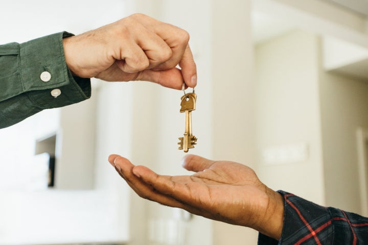 Relator giving house keys to new owner hands close-up