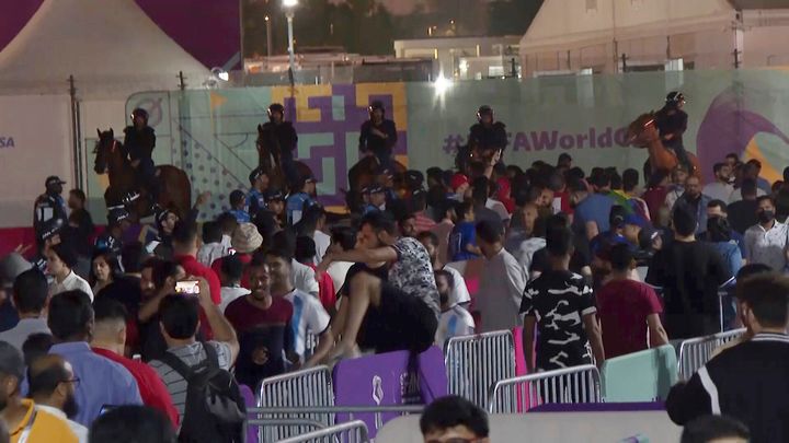 In this image from video, Qatari police stand by on horseback as other security officials try to control a crowd at a FIFA Fan Zone ahead of the World Cup in Doha, Qatar, Saturday, Nov. 19, 2022. Authorities turned away thousands of fans Saturday night from a concert celebrating the World Cup beginning the next day in Qatar, revealing the challenges ahead for Doha as it tries to manage crowds in FIFA's most-compact tournament ever. (AP Photo/Srdjan Nedeljkovic)