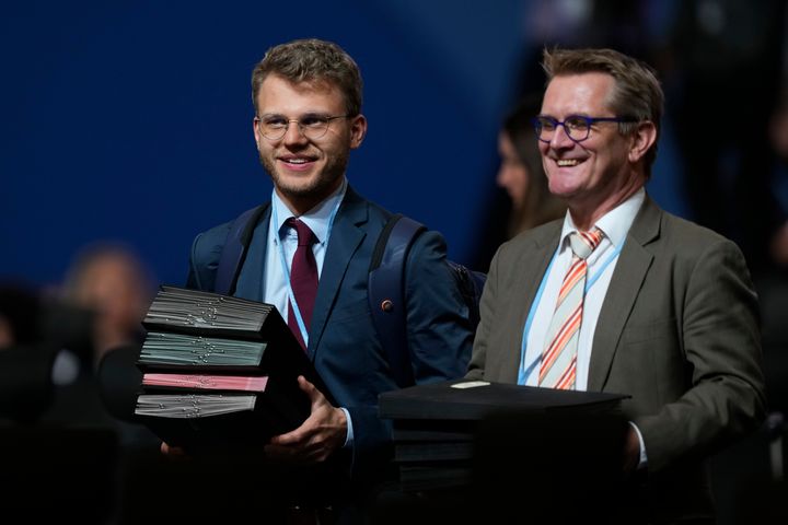 Documents are brought in for a closing plenary session at the COP27 U.N. Climate Summit, Sunday, Nov. 20, 2022, in Sharm el-Sheikh, Egypt. (AP Photo/Peter Dejong)