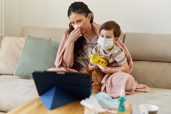 Mother and her son consulting with their doctor over a video call on their digital tablet