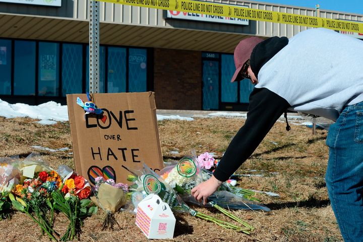 Elijah Newcomb of Colorado Springs lays flowers near a nightclub in Colorado Springs on Sunday where several people were shot and killed overnight.