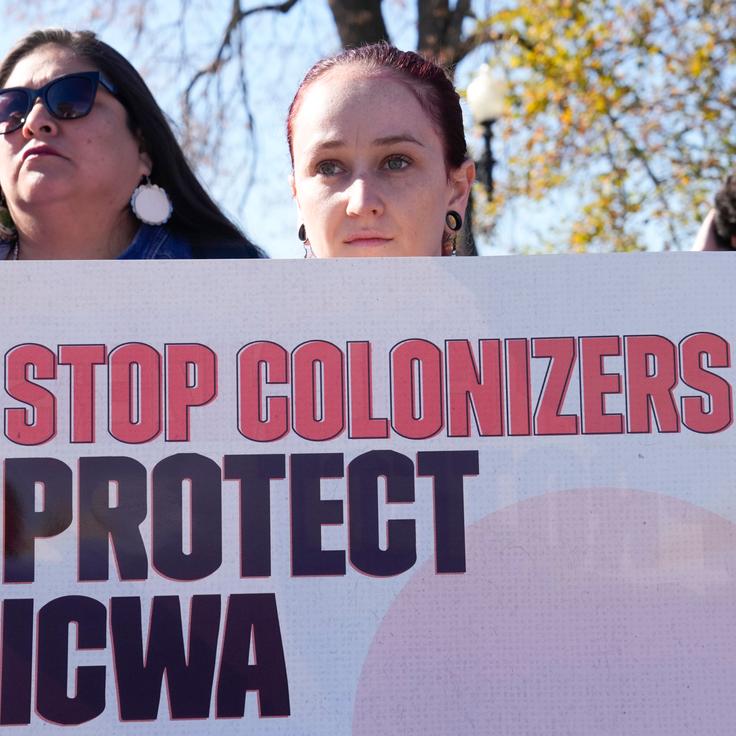 Demonstrators stand outside of the U.S. Supreme Court, as the court hears arguments over the Indian Child Welfare Act, on Nov. 9, 2022, in Washington. The Supreme Court is wrestling with a challenge to a federal law that gives preference to Native American families in foster care and adoption proceedings of Native children.